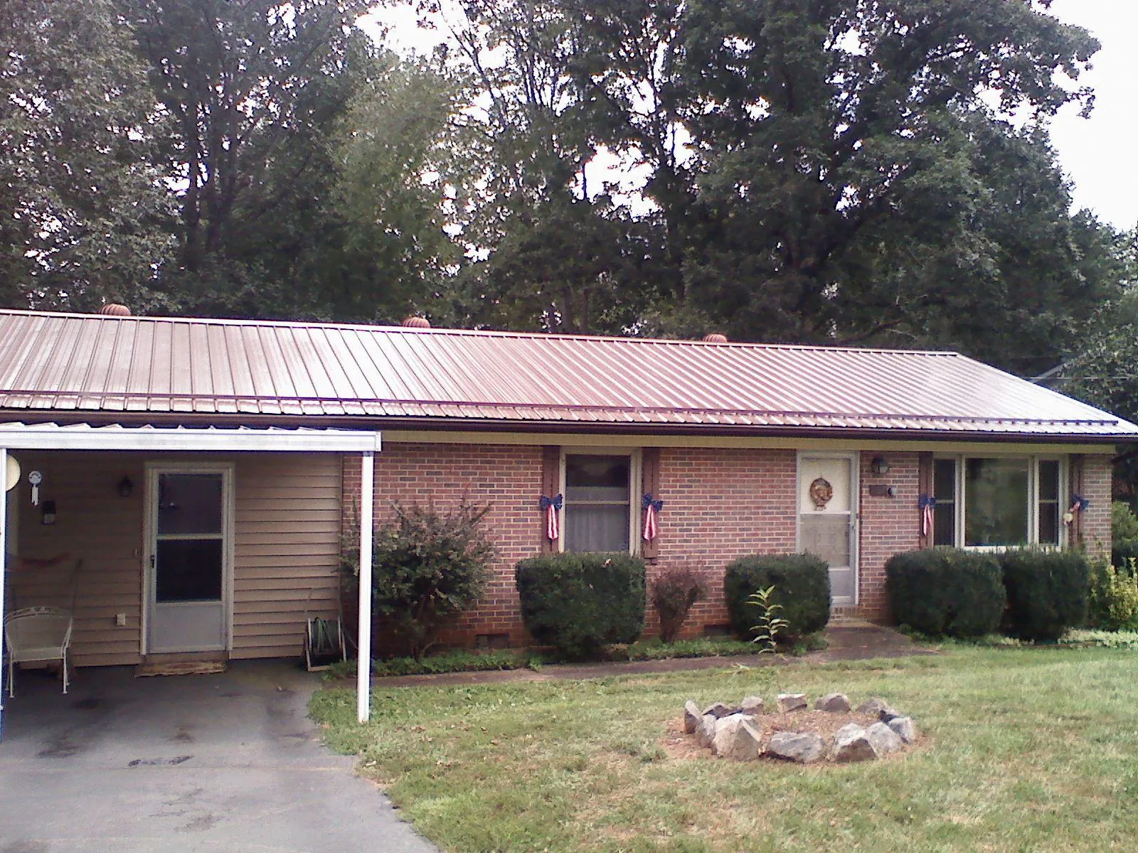 Bronze metal roof and carport on a brick ranch home — Roof Repair work by our crew in Medora